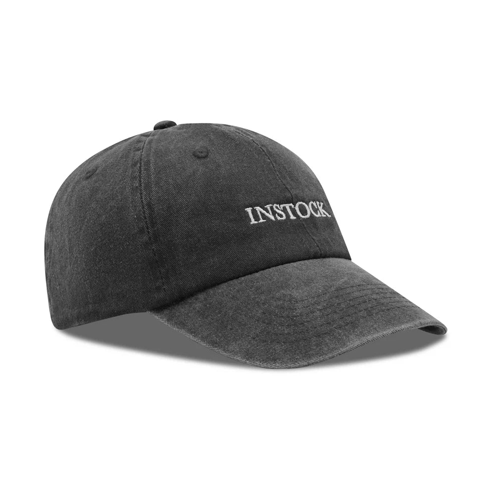 INSTOCK The In Cap in black with white logo, original side-angle product view on white background